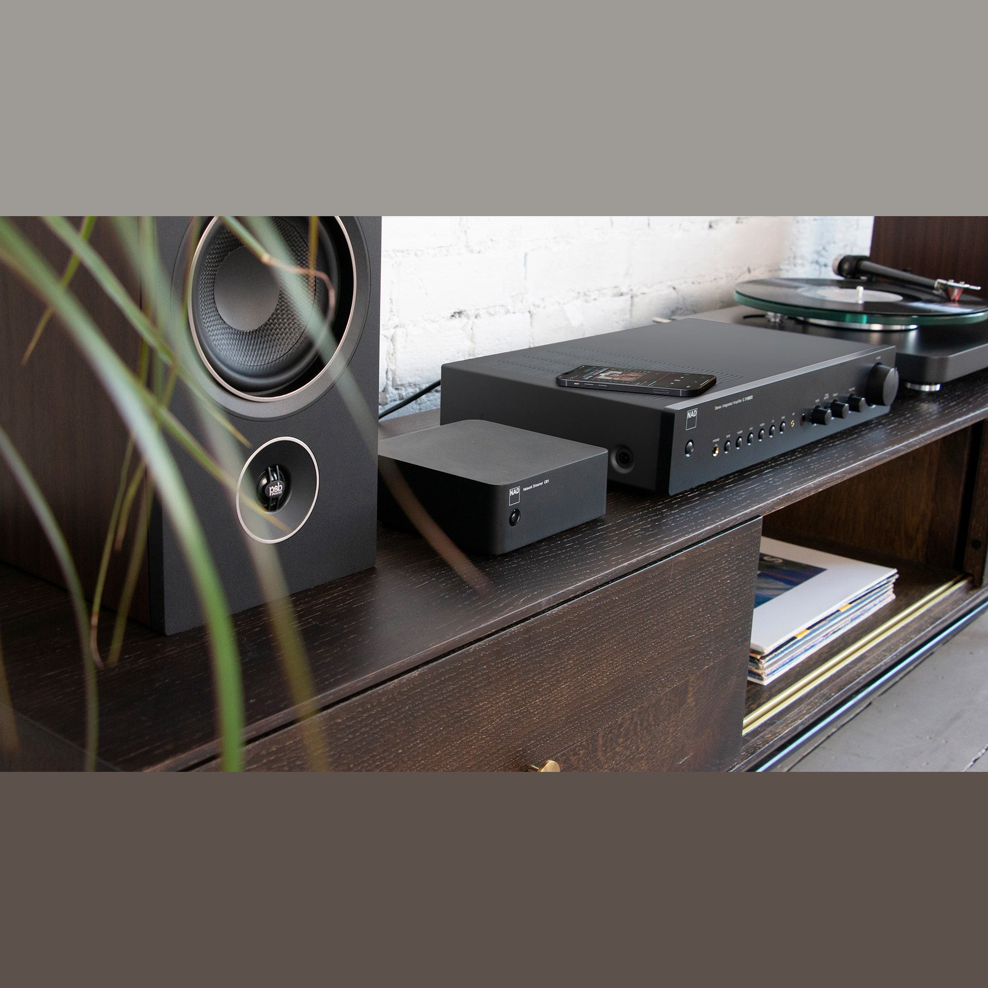 NAD CS1 Netzwerk-Streamer Lifestyle auf Sideboard mit Lautsprecher Verstärker und Plattenspieler