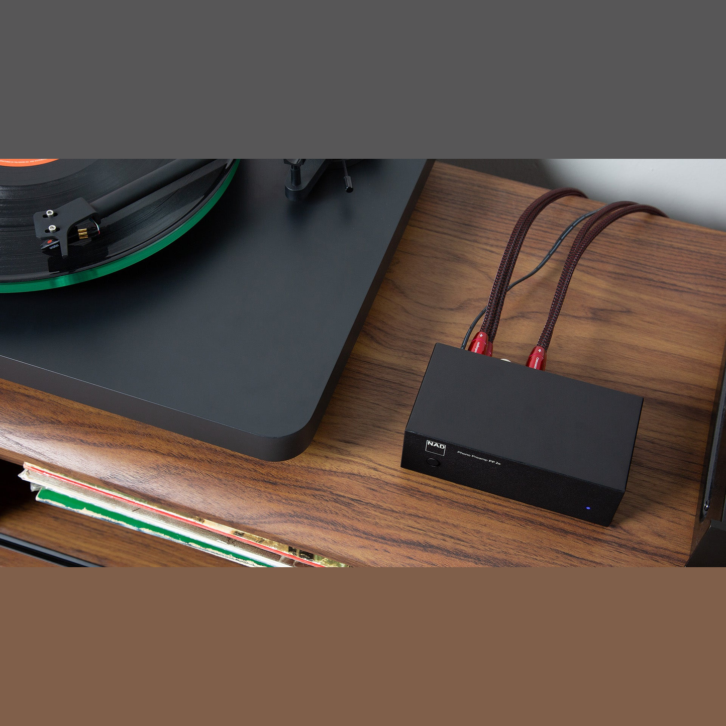 NAD PP 2e Phono-Vorverstärker Lifestyle auf Sideboard neben Plattenspieler von oben