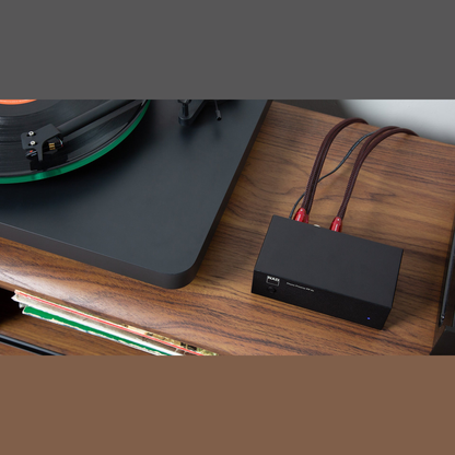 NAD PP 2e Phono-Vorverstärker Lifestyle auf Sideboard neben Plattenspieler von oben