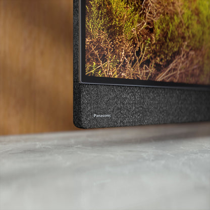Panasonic TV-77Z95BEKA OLED-Fernseher Detailansicht Panasonic-Schriftzug Lautsprecherbespannung