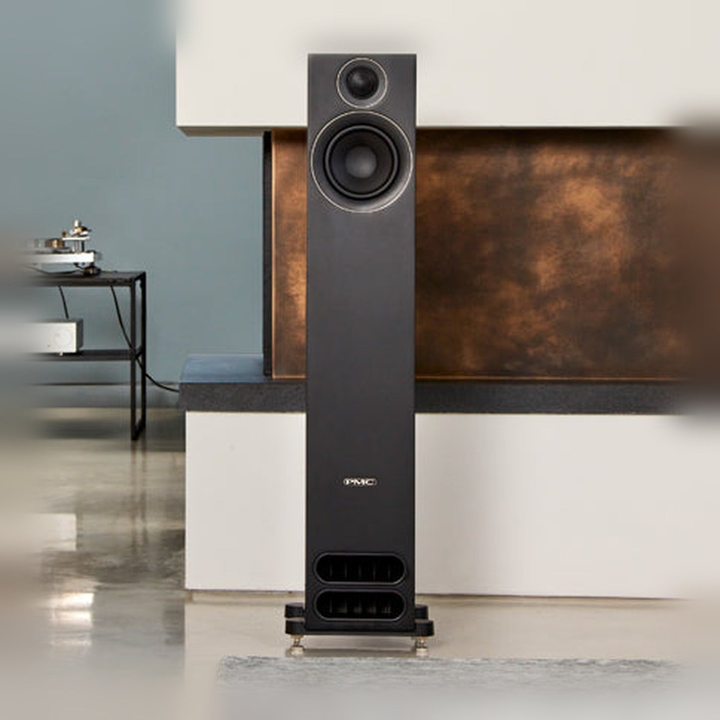 PMC Prodigy 5 Standlautsprecher Lifestyle vor Kupferwand mit Plattenspieler