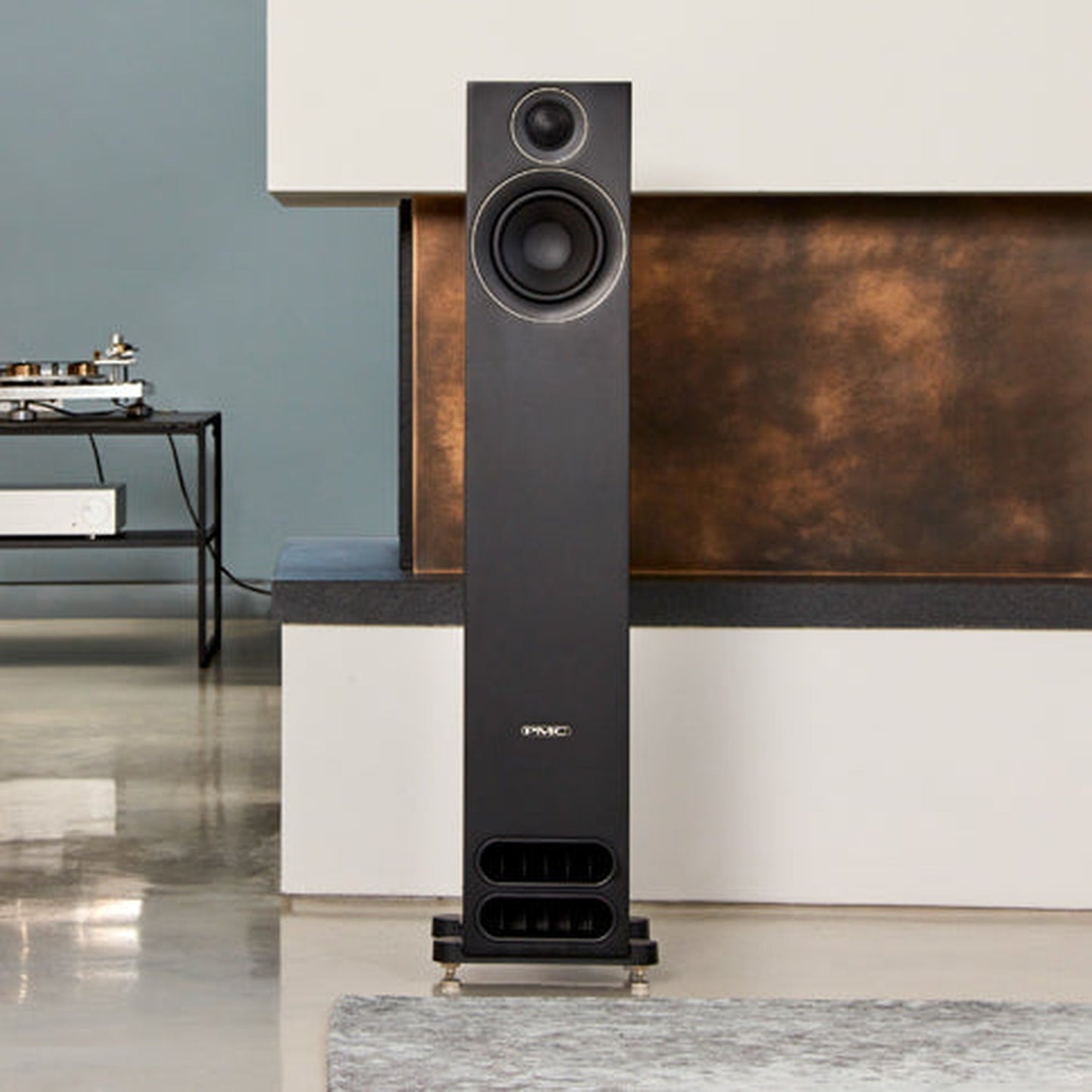 PMC Prodigy5 Standlautsprecher Schwarz Lifestyle im Wohnraum vor Kupferpaneel