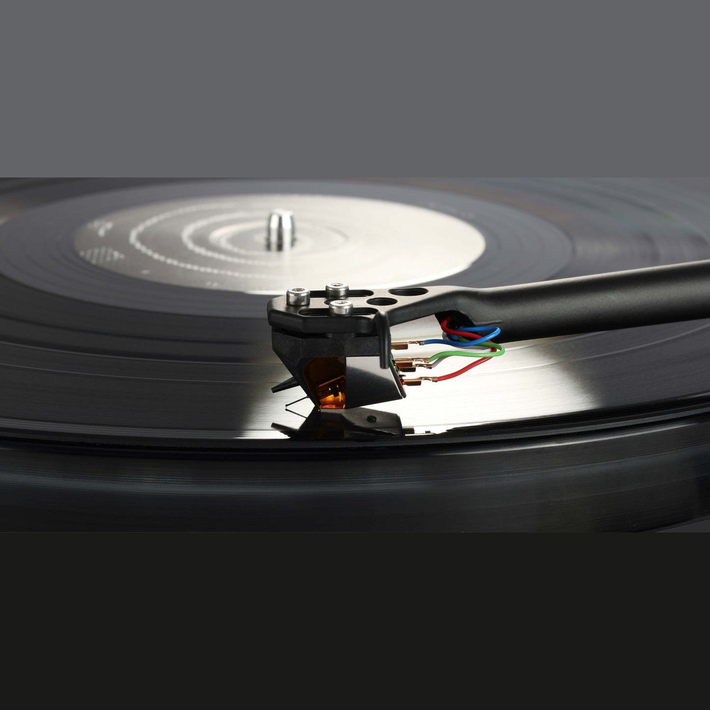Rega ND9 MM-Tonabnehmer, Detailansicht am Tonarm montiert mit Blick auf Plattenteller-Spindel