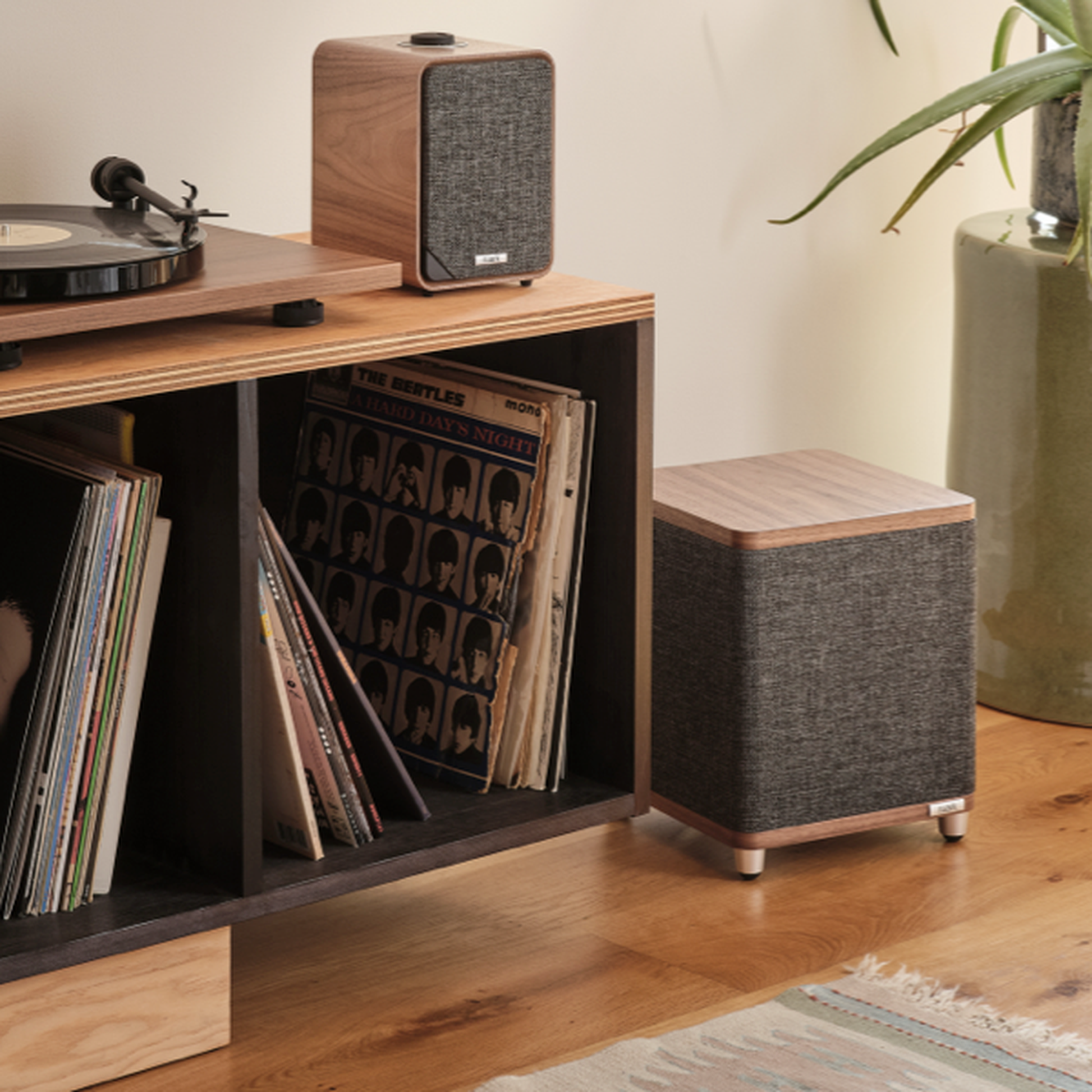 Ruark RS1 Aktiv-Subwoofer Nussbaum Lifestyle neben Plattenregal