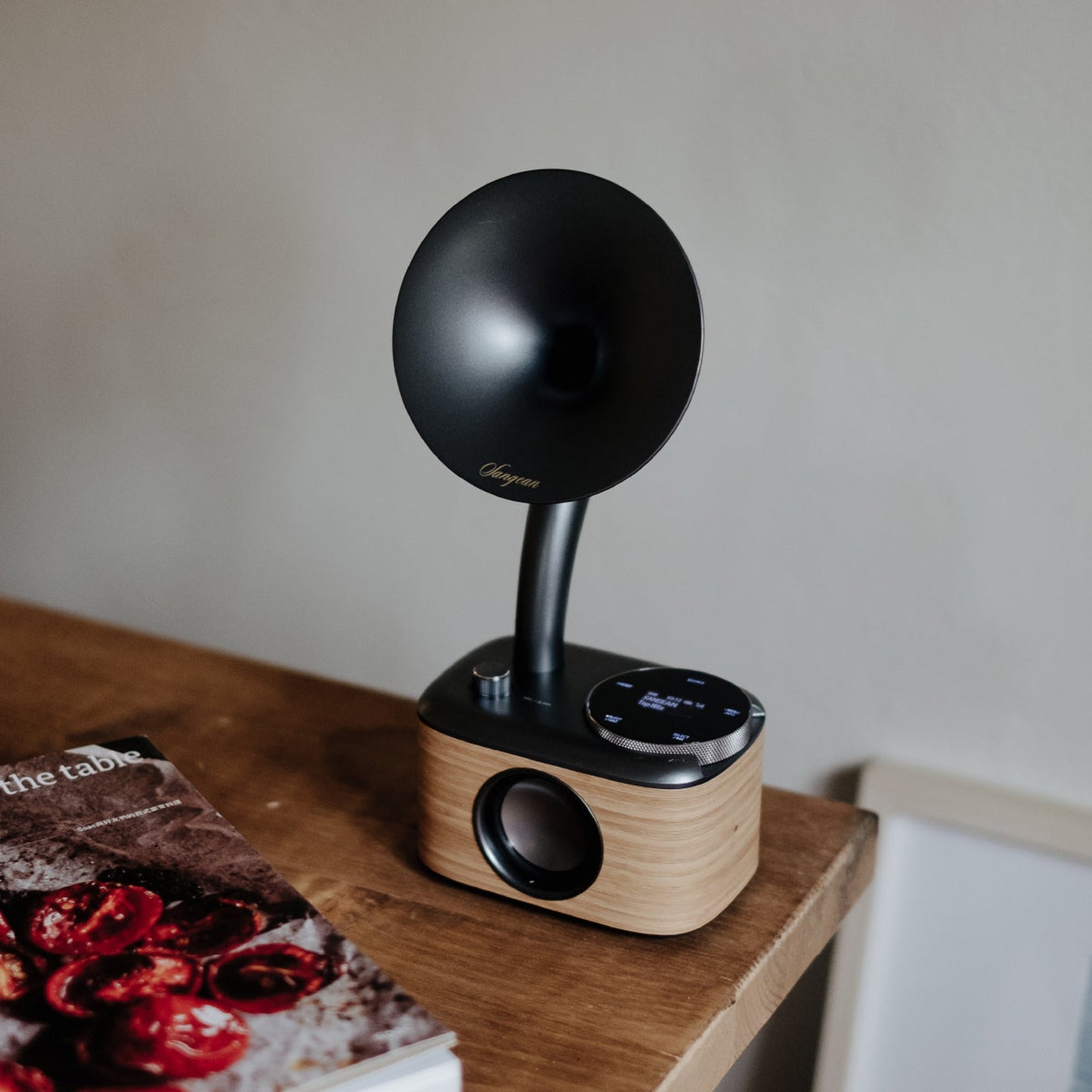 Sangean CP-100D DAB+/UKW Radio Lifestyle auf Holztisch neben Kochbuch in Lightwood-Grey