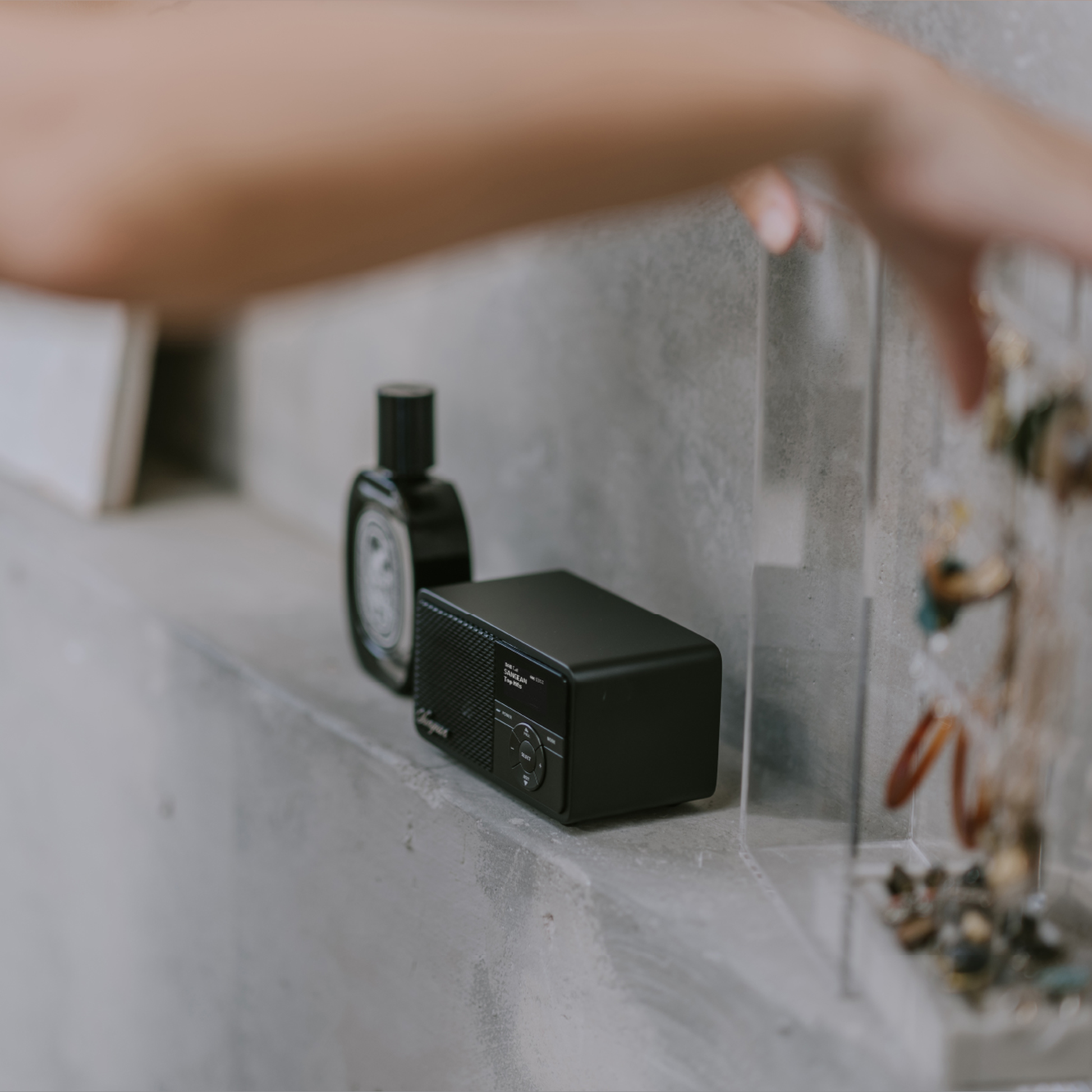 Sangean DDR-7X DAB+ Holzradio mit Akku Lifestyle auf Betonablage neben Vintage-Uhr in Black