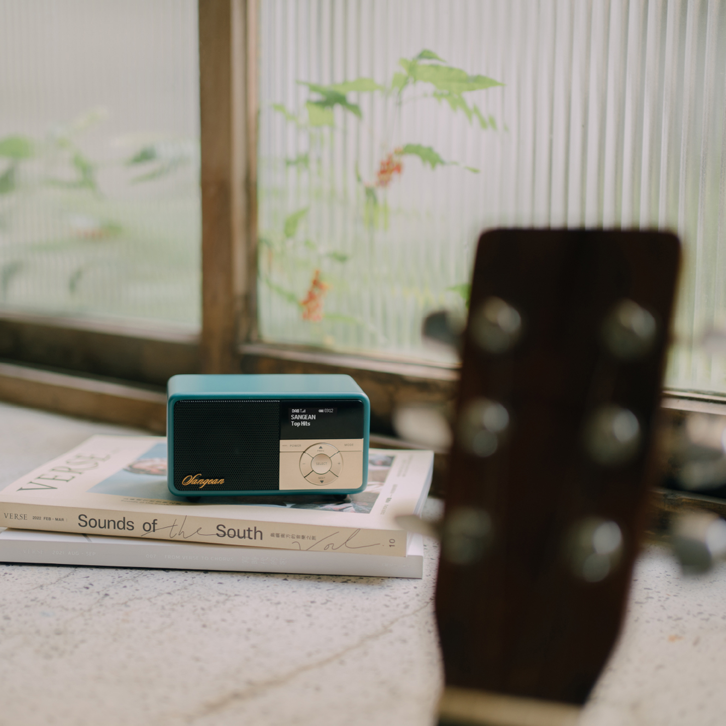Sangean DDR-7X DAB+ Holzradio mit Akku Lifestyle auf Büchern neben Gitarre in Green