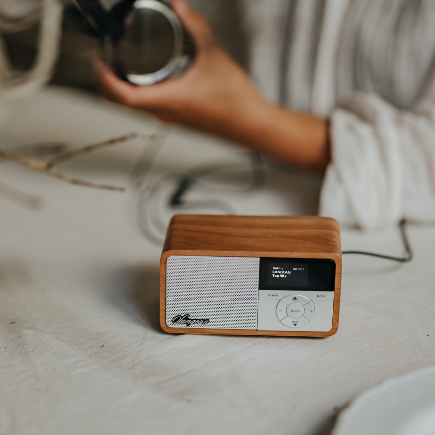 Sangean DDR-7X DAB+ Holzradio mit Akku Lifestyle auf Tisch neben Kopfhörer in Light Wood