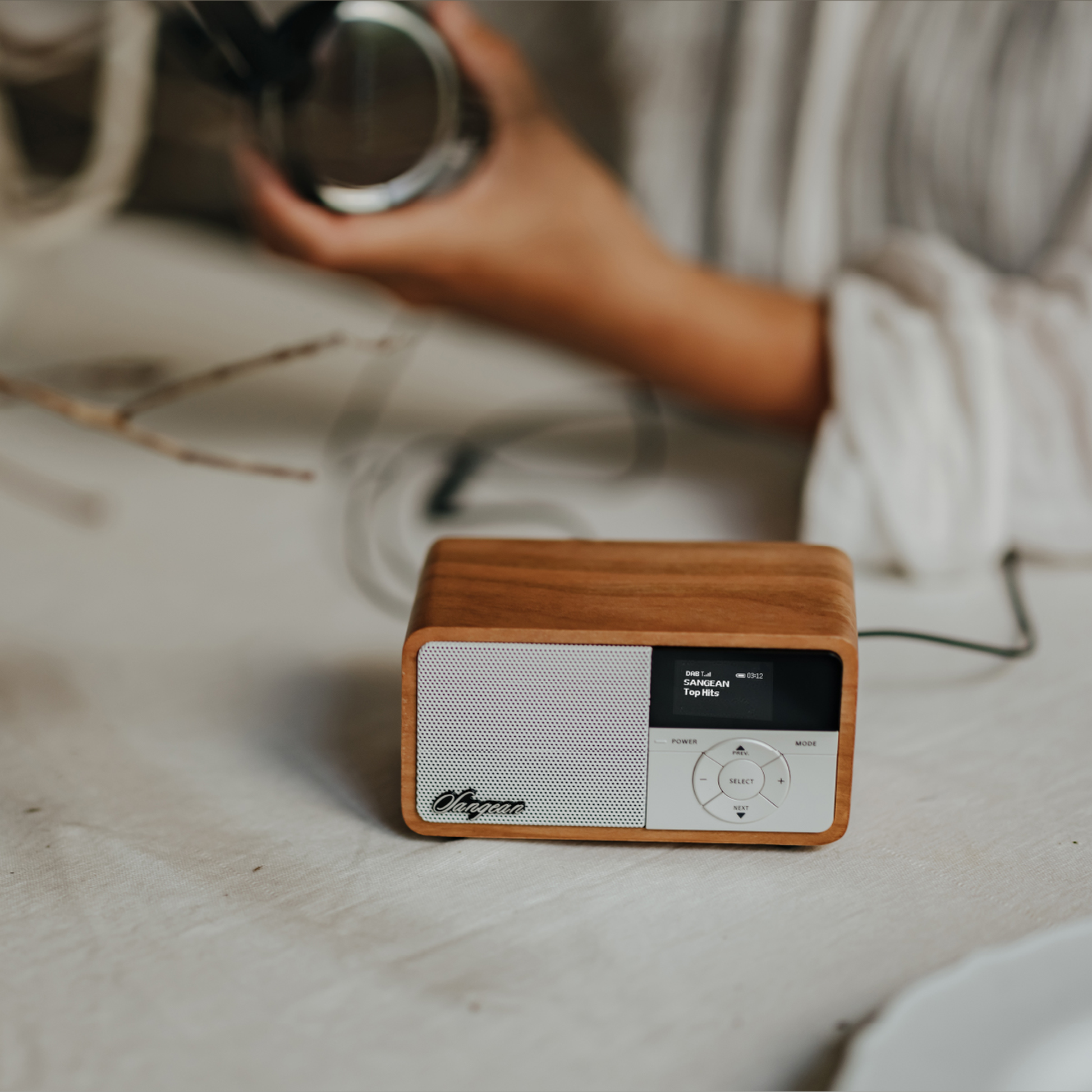 Sangean DDR-7X DAB+ Holzradio mit Akku Lifestyle auf Tisch neben Kopfhörer in Light Wood