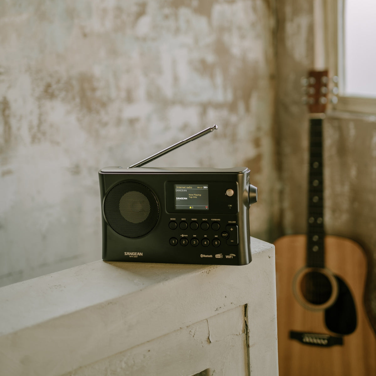Sangean WFR-28BT Portables Internetradio, Black, Lifestyle auf Mauer mit Gitarre