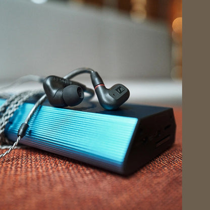 Sennheiser IE 200 In-Ear-Kopfhörer Lifestyle mit tragbarem Verstärker auf Tisch