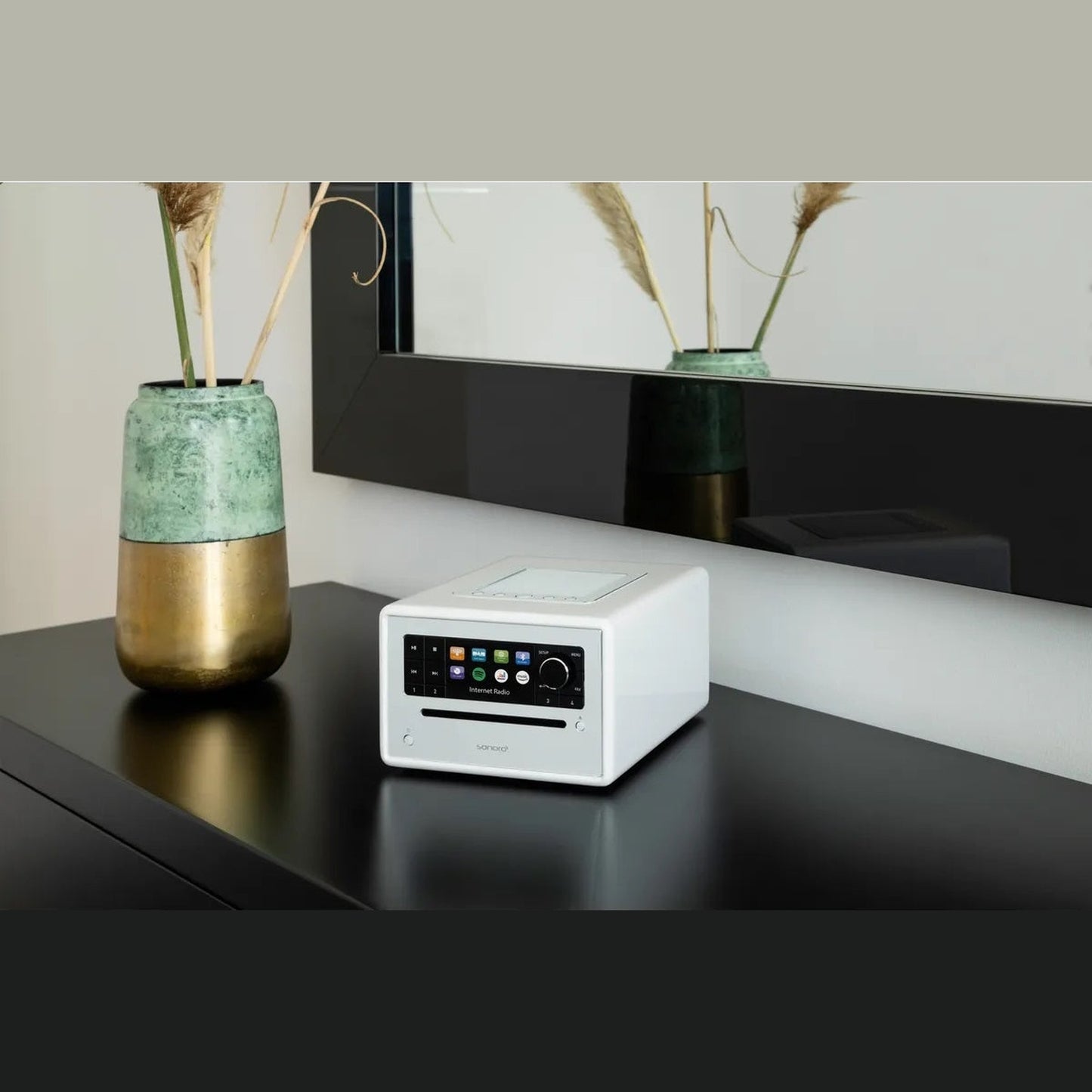 Sonoro Elite Internetradio Lifestyle auf schwarzem Sideboard mit Vase, Weiss hochglänzend