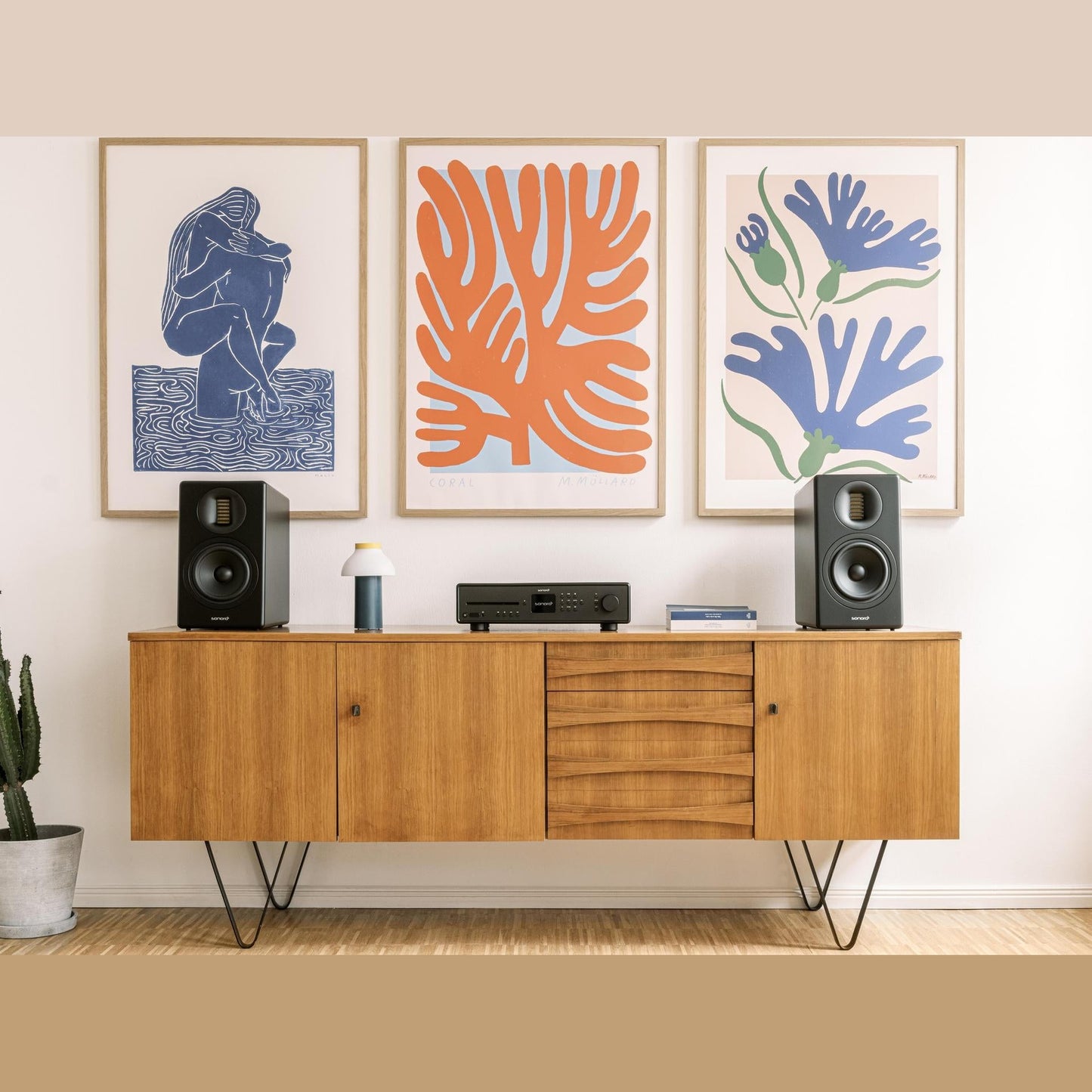 Sonoro Orchestra Gen.2 Regallautsprecher Lifestyle Paar auf Sideboard vor Kunstdrucken, Schwarz matt