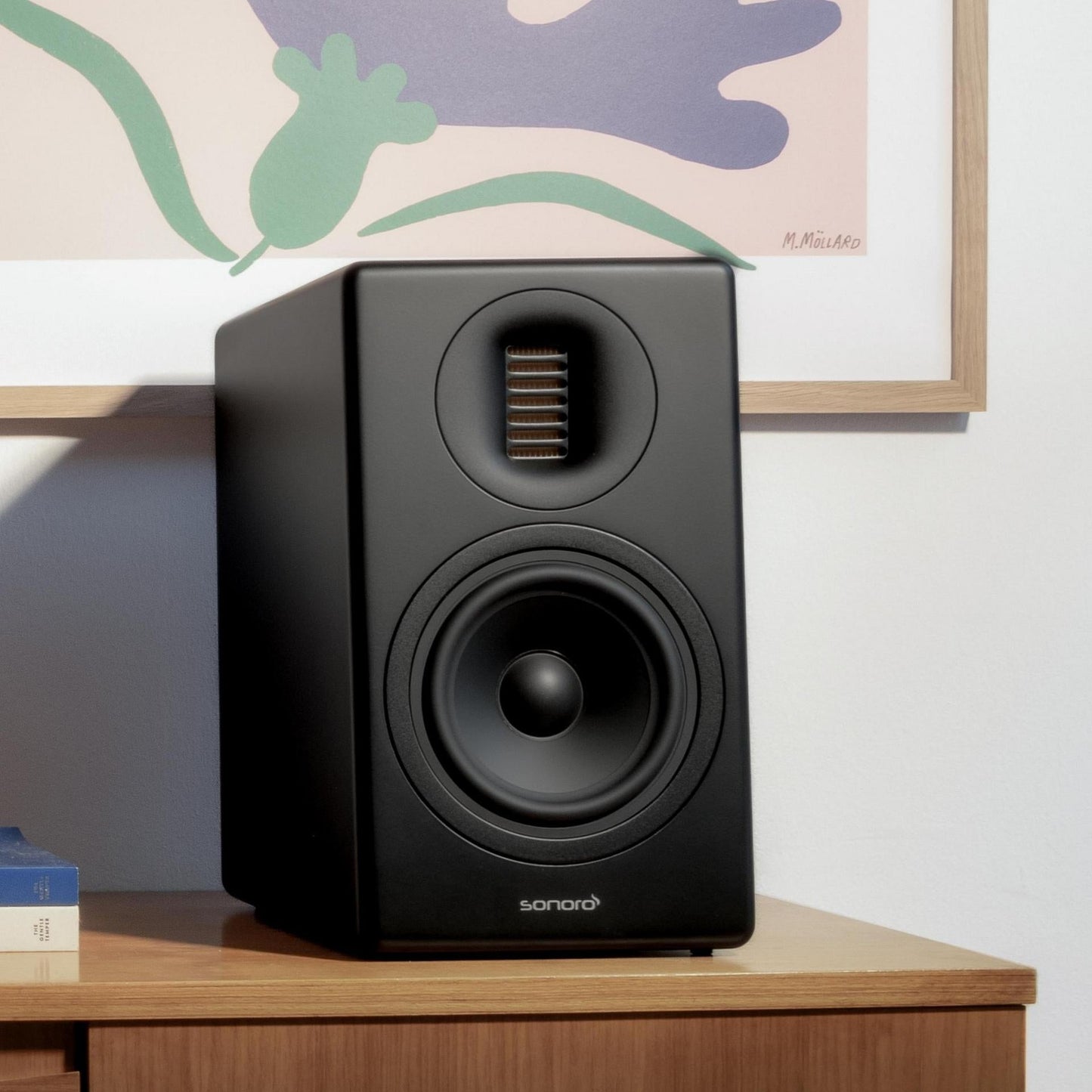 Sonoro Orchestra Gen.2 Regallautsprecher Lifestyle auf Sideboard vor Wandbild, Schwarz matt