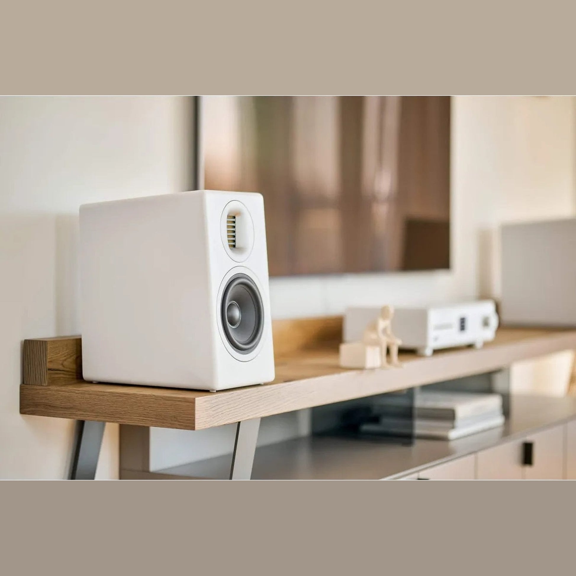 Sonoro Orchestra Gen.2 Regallautsprecher Lifestyle auf Holzkonsole vor Fernseher, Weiss matt