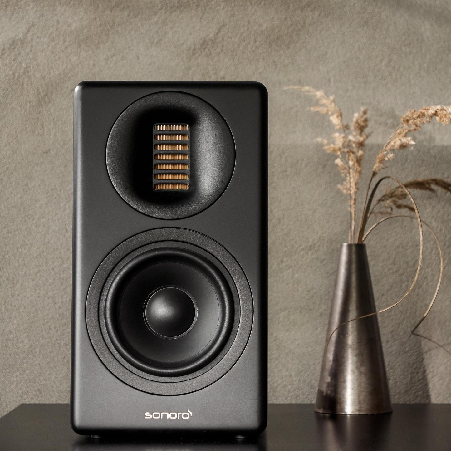 Sonoro Orchestra Slim Regallautsprecher Lifestyle auf Sideboard mit Trockengras, Schwarz matt