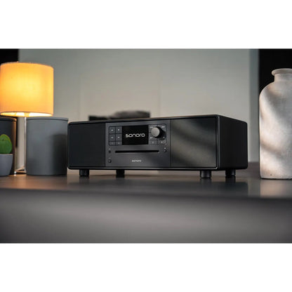 Sonoro Prestige All-in-One Lifestyle auf Sideboard neben Tischlampe, Schwarz matt