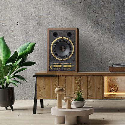 Tannoy SGM 10 Regallautsprecher Lifestyle auf einem Sideboard vor Betonwand im Wohnraum