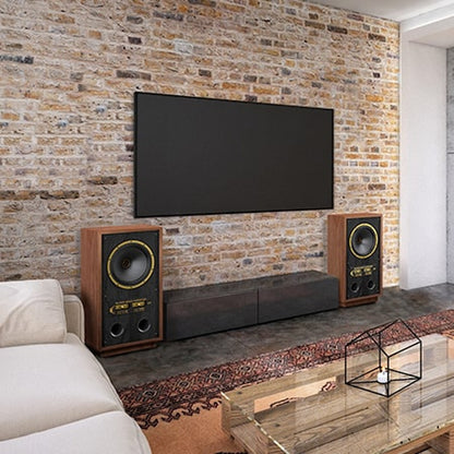 Tannoy SGM 15 Standlautsprecher Lifestyle als Paar vor Backsteinwand unter Wandfernseher