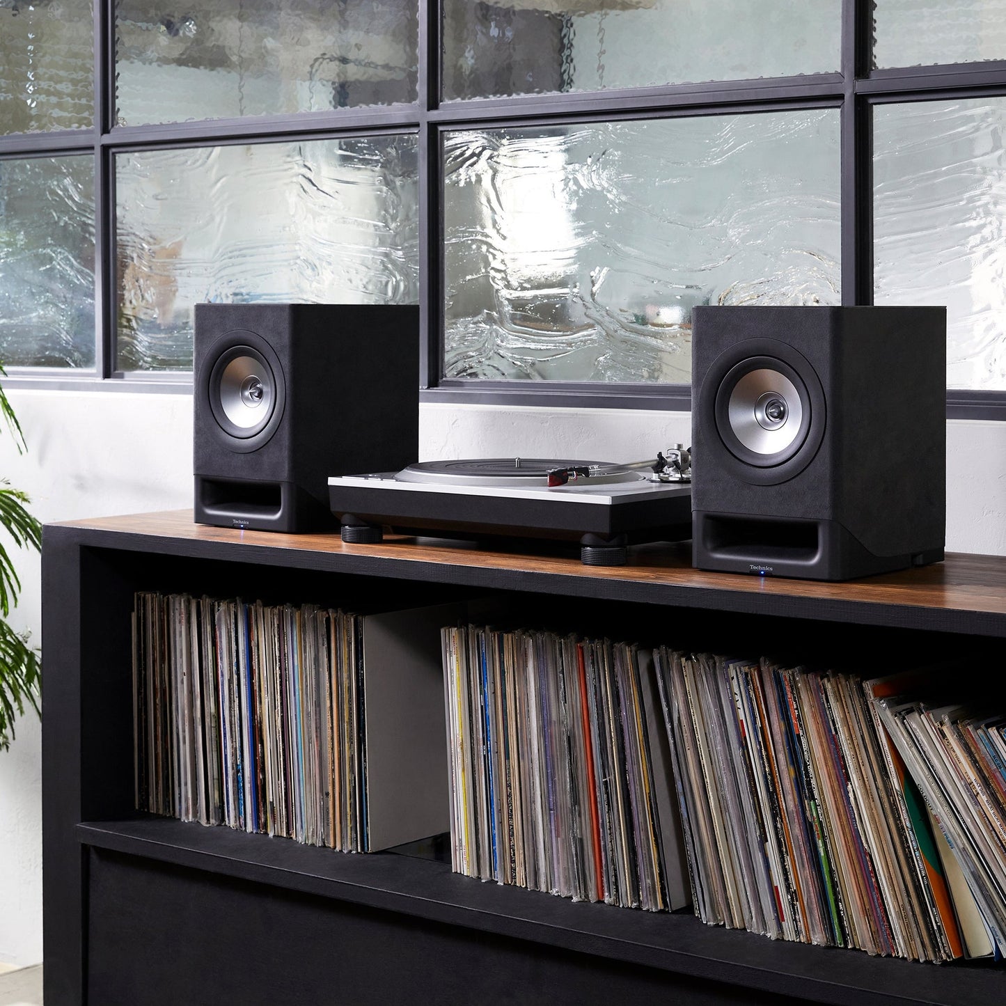 Technics SL-1500C Silber + SC-CX700 Schwarz HiFi-Set Lifestyle, Set auf einem Sideboard mit Plattensammlung