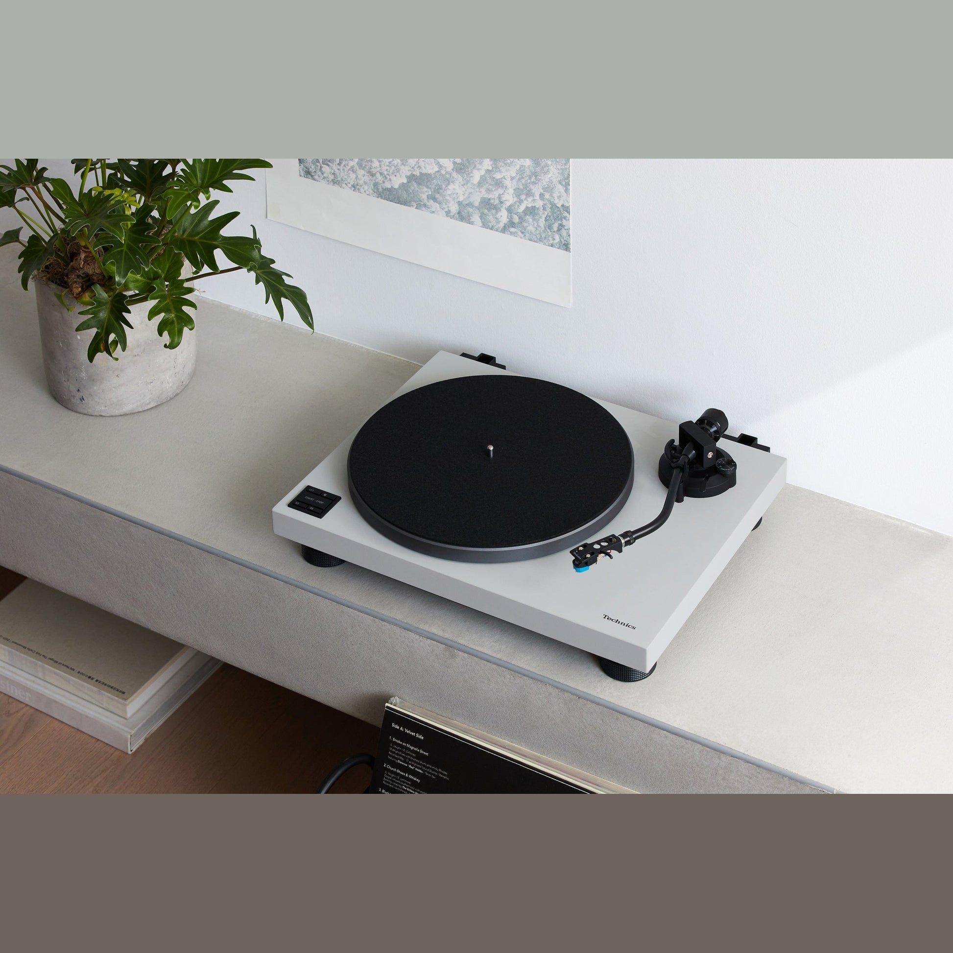 Technics SL-40CBT Plattenspieler Grau Lifestyle auf hellem Sideboard mit Pflanze und Bild