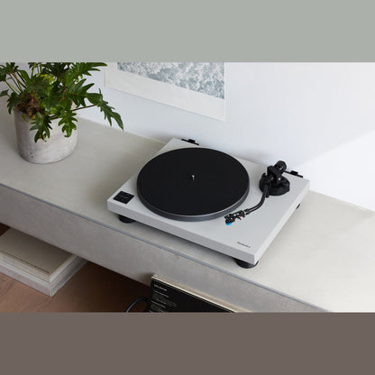 Technics SL-40CBT + SC-CX700 HiFi-Set Grau Lifestyle, Plattenspieler auf Betonsims mit Pflanze und Wandbild