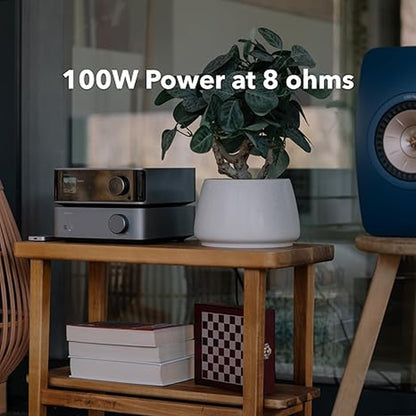 WiiM VibeLink Amp Vollverstärker Space Gray Lifestyle auf dem Beistelltisch neben Kompaktlautsprecher