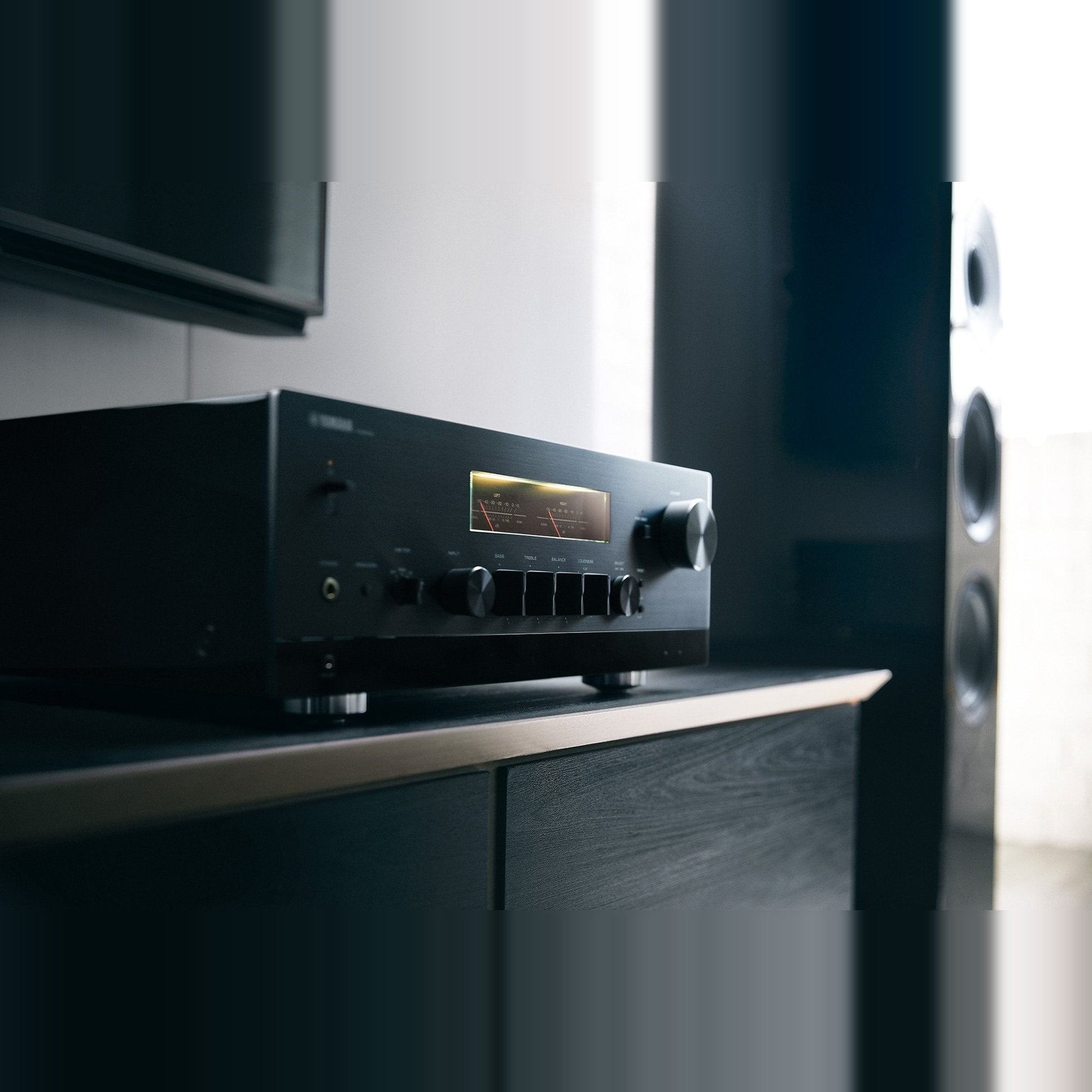 Yamaha R-N2000A Netzwerk-Receiver Schwarz Lifestyle auf Sideboard neben einem Standlautsprecher
