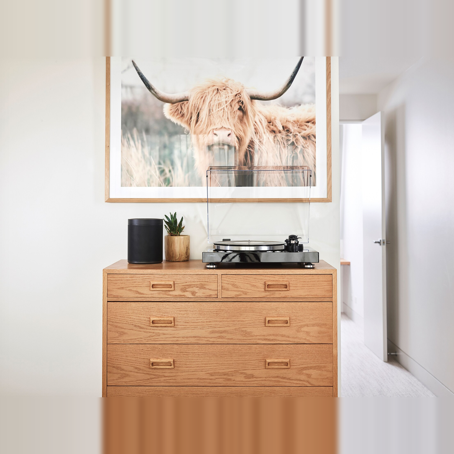 Yamaha TT-N503 MusicCast-Plattenspieler Schwarz Lifestyle auf Kommode mit Lautsprecher und Bild